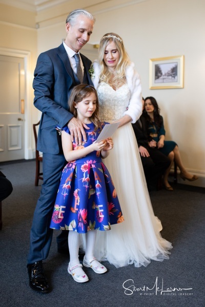 Newlyweds and daughter reading message at Stockport Town Hall