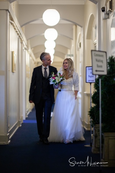 Bride and Groom making their way down the corridor of Stockport Town Hall