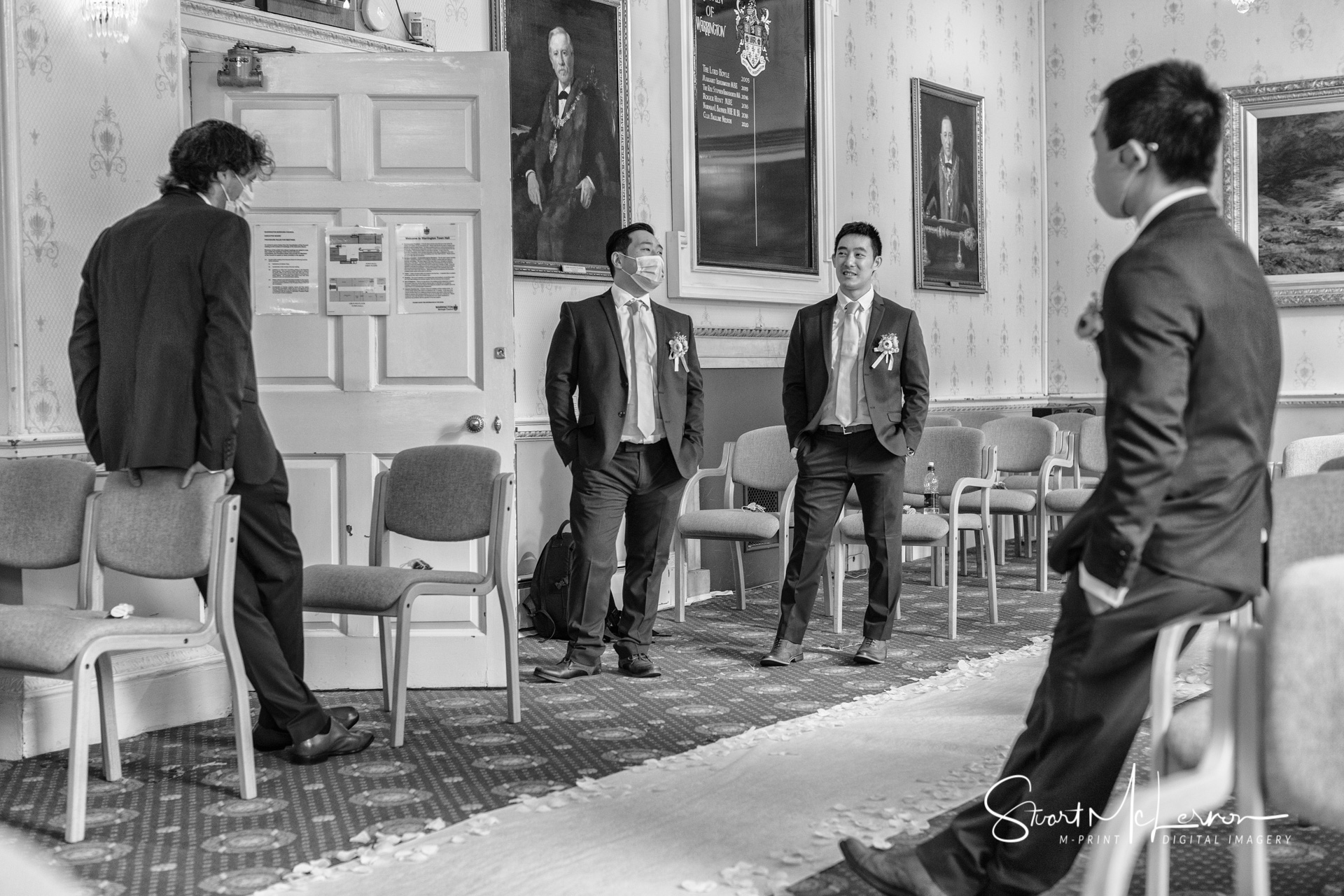 The groom and his groomsmen are socially distanced before the wedding ceremony at Warrington Town Hall