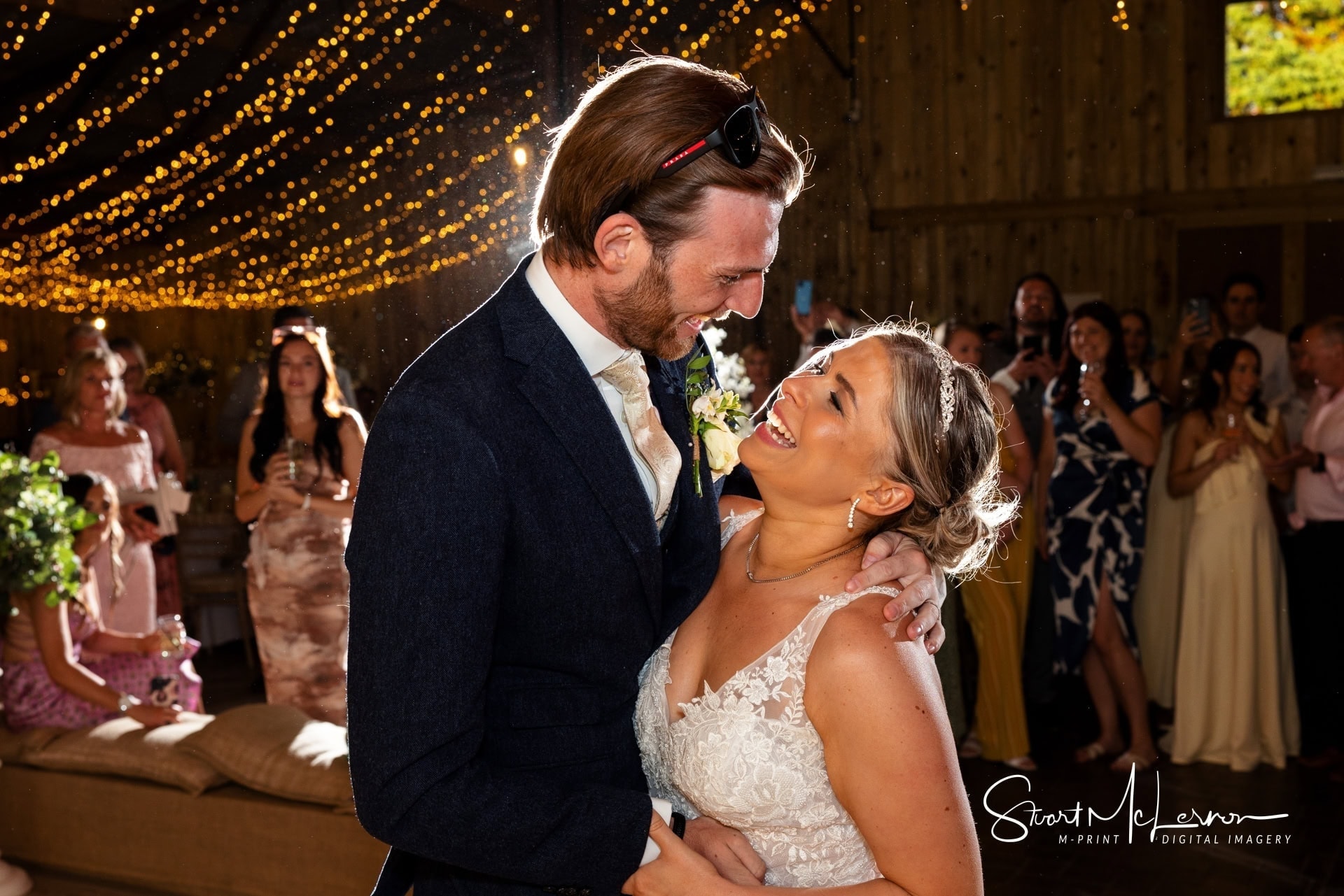 The bride and groom are backlit as thewy take their first dance as man and wife at Alcumlow Wedding Barn.