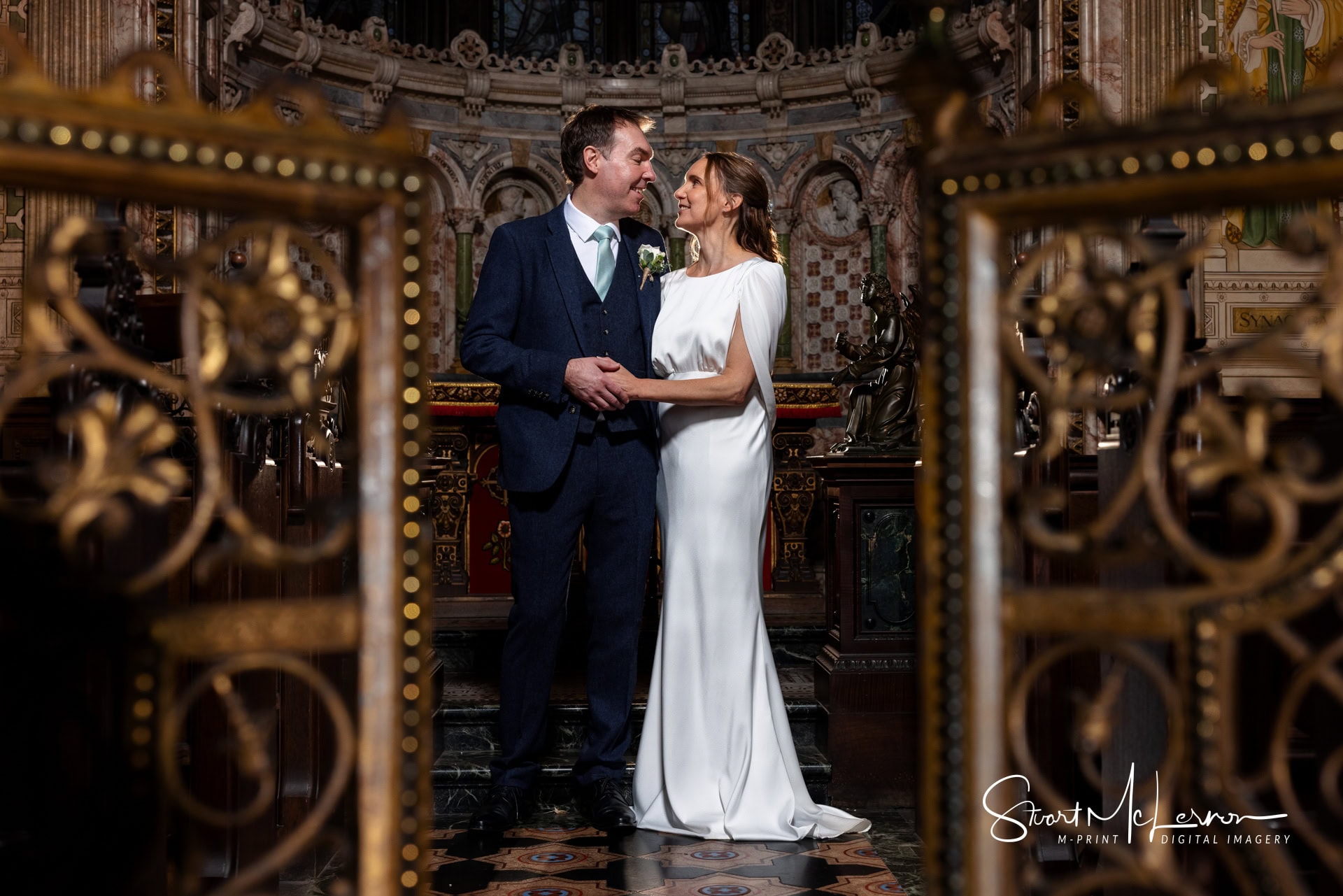 The newlyweds pose for a lit portrait in the Chapel at Crewe Hall