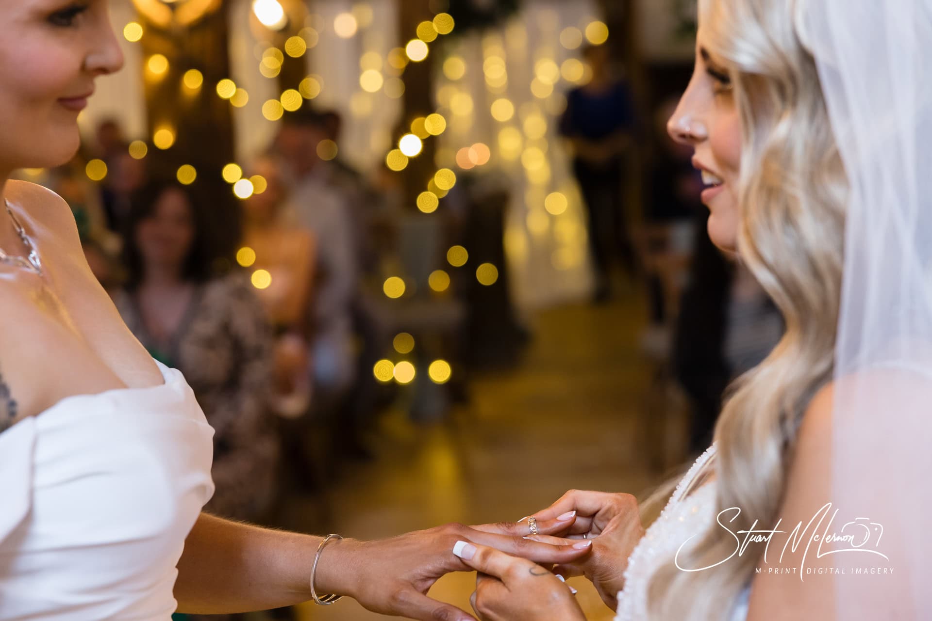 The brides places a wedding ring on her bride's finger during their wedding ceremony at the Plough Inn Eaton